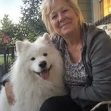 Dog parent on a porch with a white Samoyed